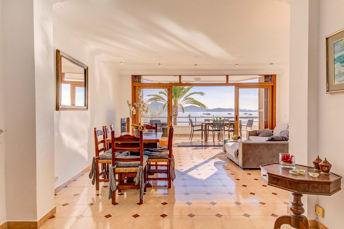 A dining room with a table and chairs and a view of the ocean