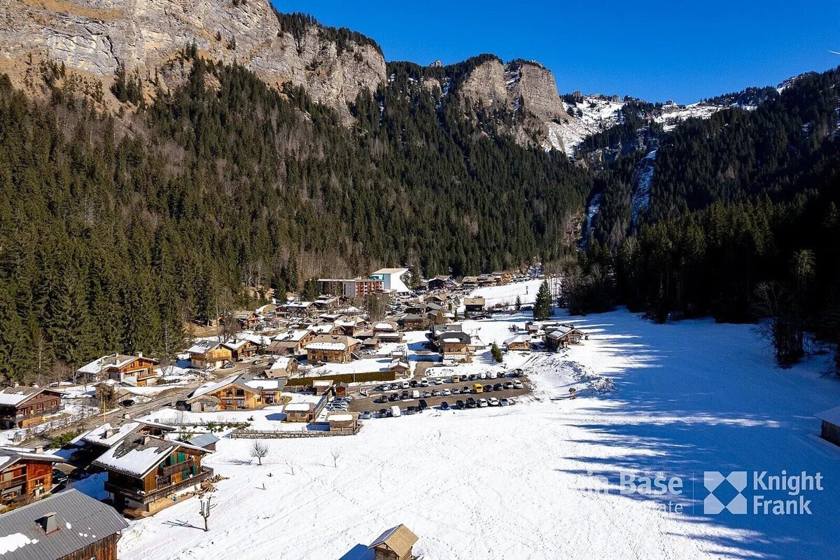 An aerial view of a snowy mountain village taken by knight frank