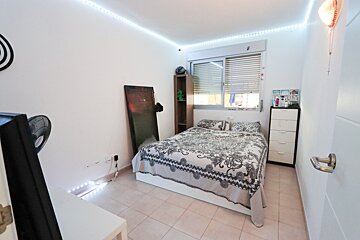 A bedroom with a bed and a fan and a sign on the wall that says 