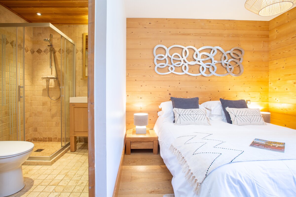 A bedroom with a large bed and a bathroom