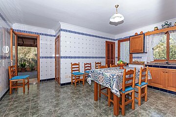 A kitchen with blue and white tiles and a table and chairs