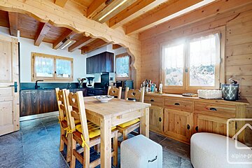 A kitchen with a wooden table and chairs and a sign that says alpine-pro