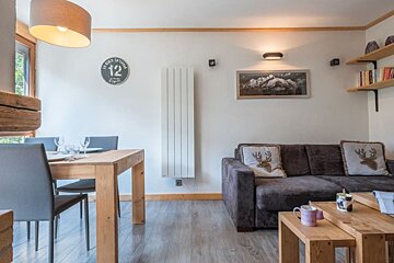 A living room with a couch and a clock that says 12