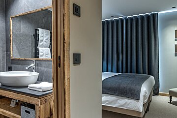 A bathroom with a sink a mirror and a bed