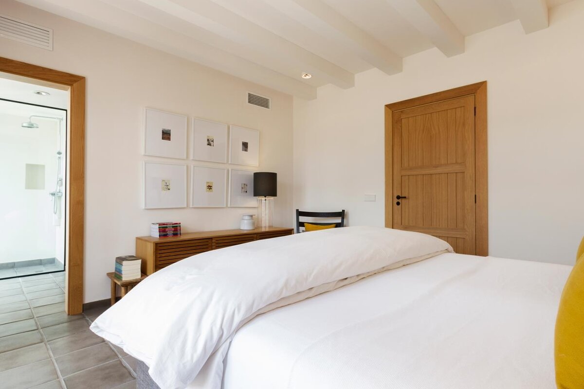 A bedroom with a white bed and a wooden door