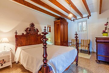 A bedroom with a four poster bed and a dresser