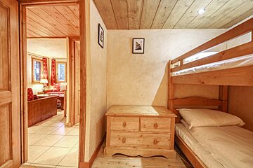A bedroom with two bunk beds and a dresser