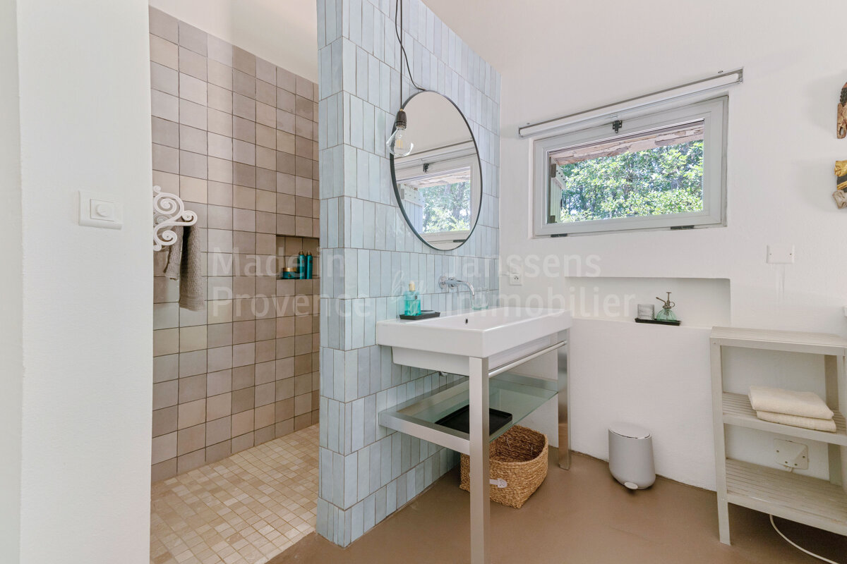 A bathroom with a sink and a mirror and provence immobilier written on the wall
