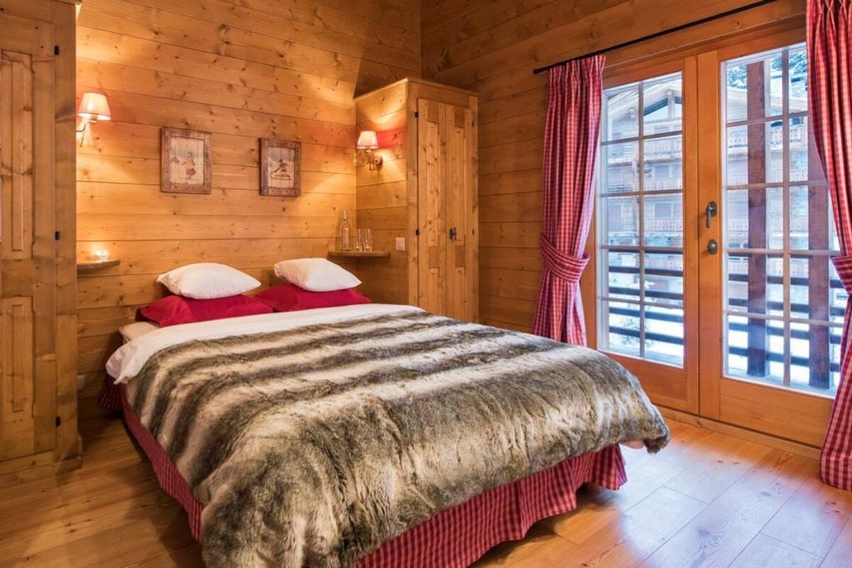 A bed with a fur blanket in a wooden room