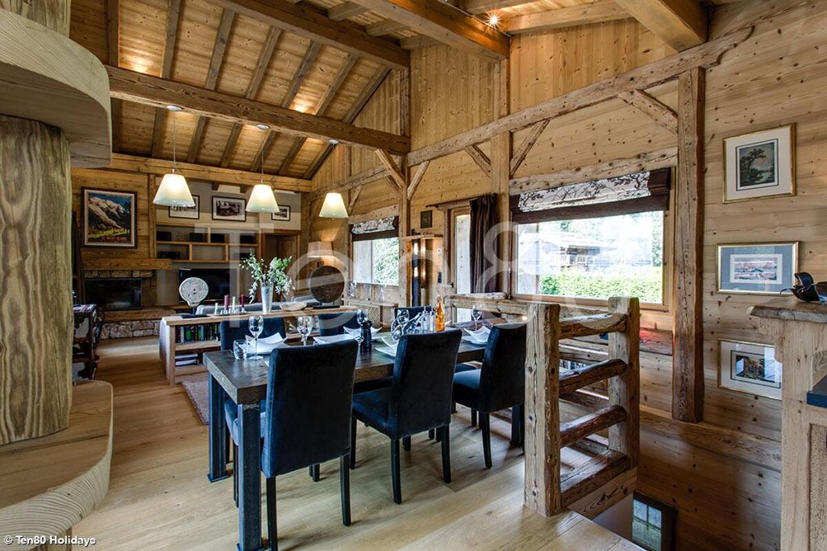 A wooden house with a dining room table and chairs