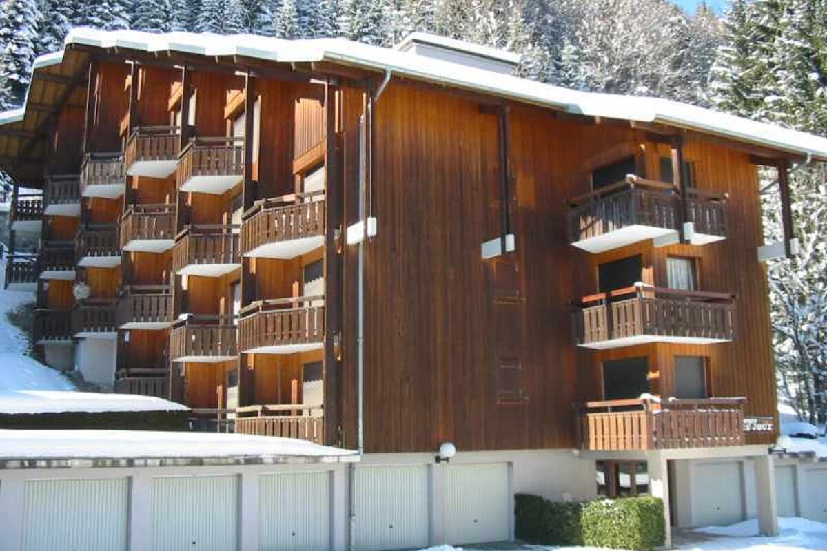 A snowy building with a tree in the foreground