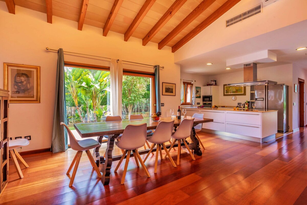 A dining room with a table and chairs and a kitchen