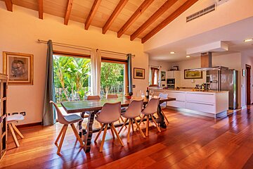 A dining room with a table and chairs and a kitchen