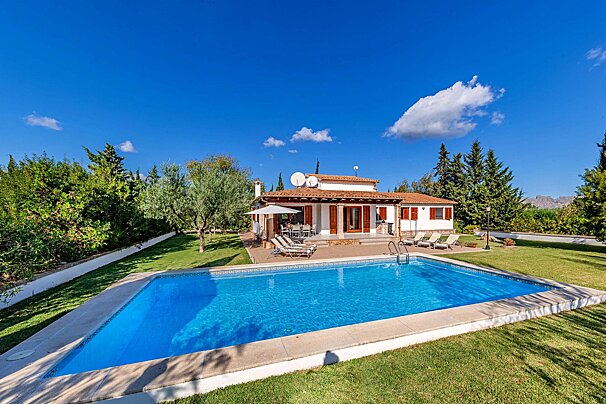 A house with a large swimming pool in front of it
