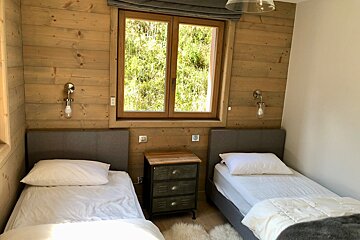 A bedroom with two twin beds and a window