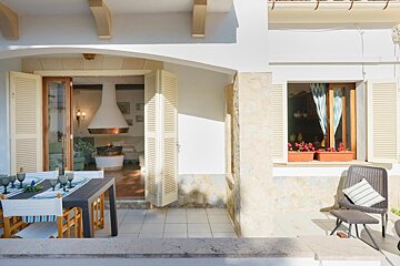 A patio with a table and chairs and a fireplace