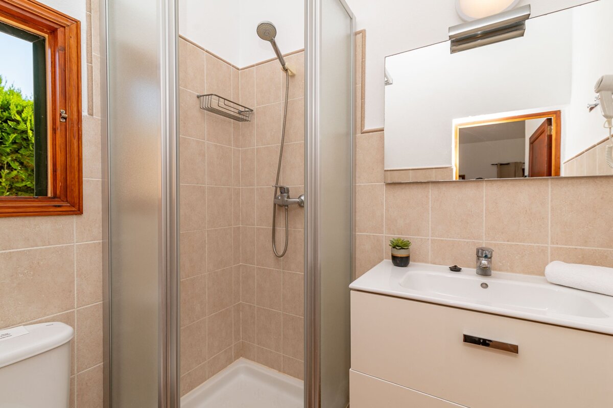 A bathroom with a walk in shower and a sink