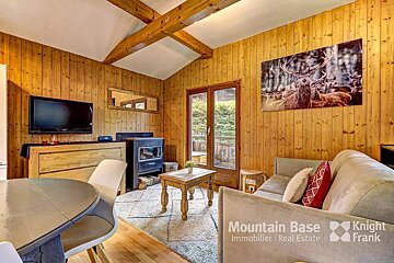 A living room with a picture of a deer on the wall and the words mountain base knight frank on the bottom