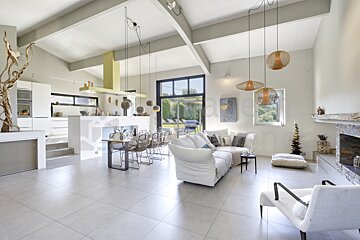 A living room with a white couch and chairs