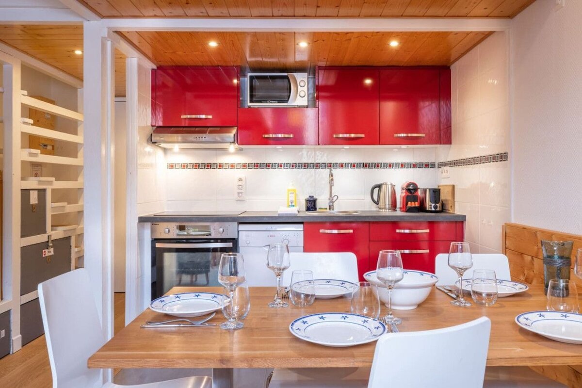 A kitchen with red cabinets and a nespresso machine