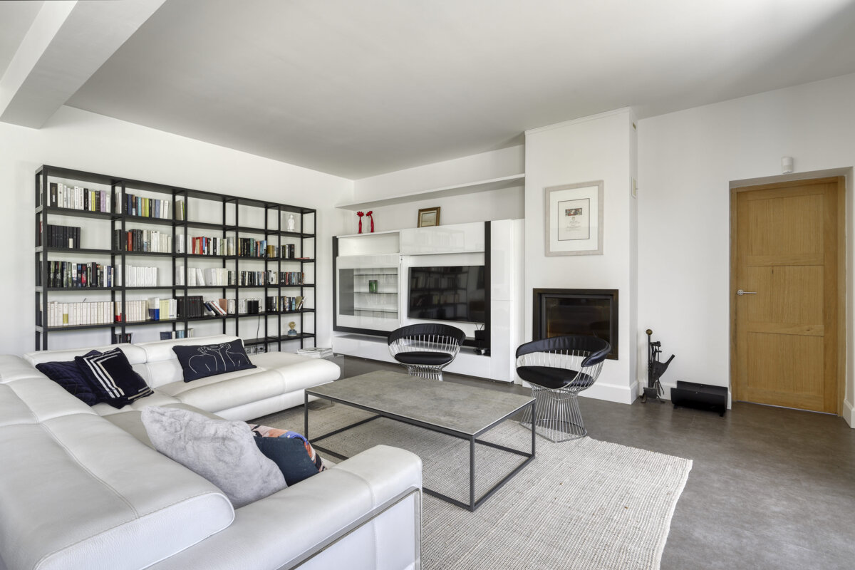 A living room with a white couch and black chairs