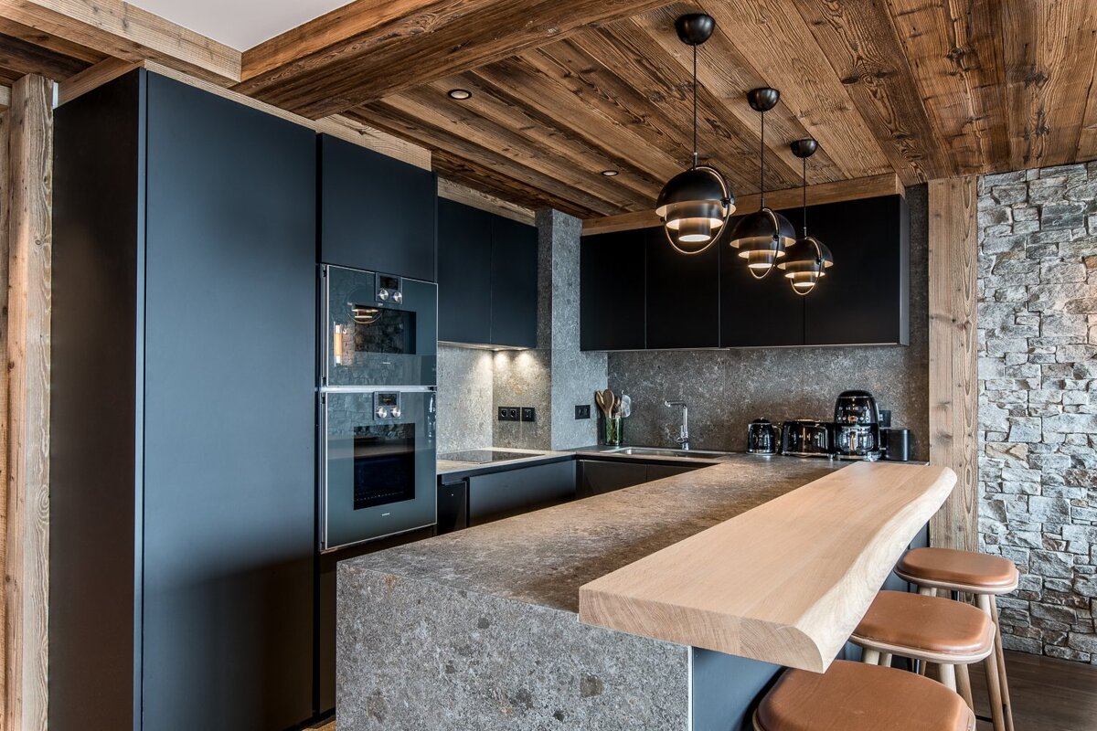 A kitchen with black cabinets and a wooden counter top