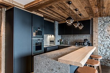 A kitchen with black cabinets and a wooden counter top