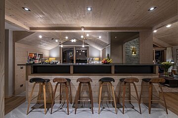 A row of bar stools are lined up in a kitchen