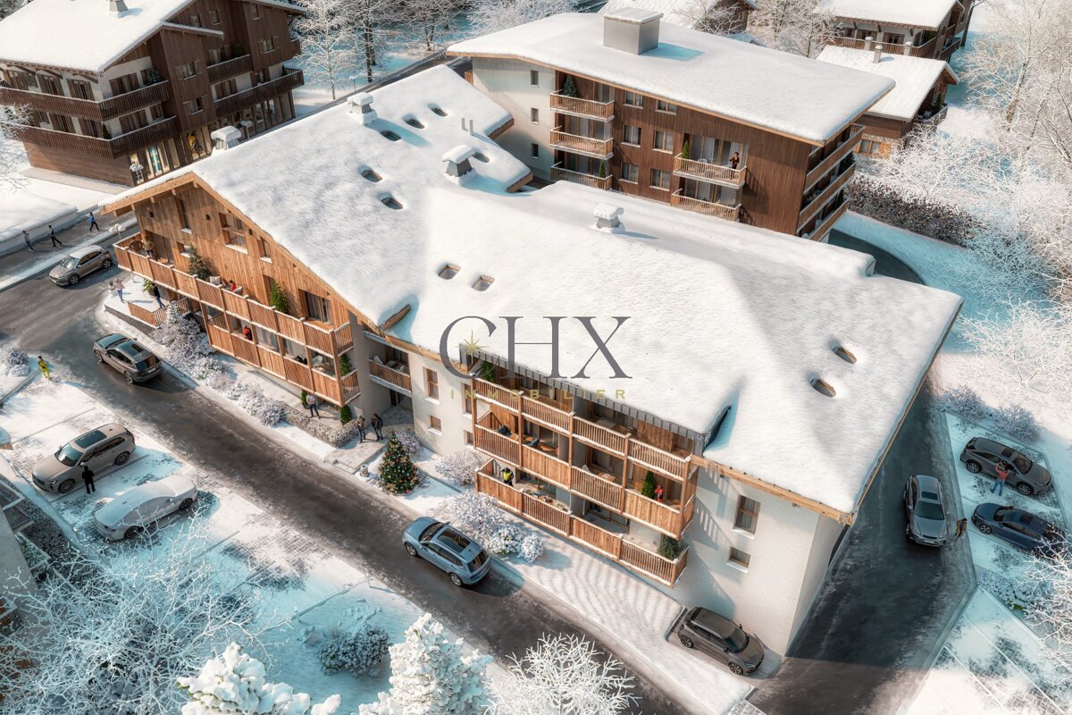 An aerial rendering of snow-covered chalets with cars parked on the streets in a winter alpine resort.