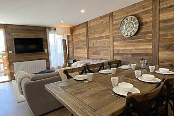 A living room with a clock on the wall that has roman numerals