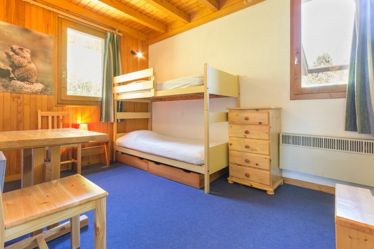 A bedroom with a bunk bed and a dresser