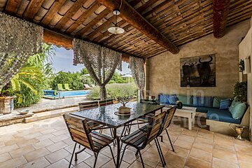 A patio with a table and chairs and a painting of bulls on the wall