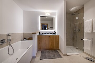 A bathroom with a bathtub a sink and a mirror