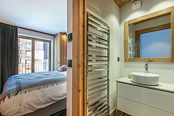 A bedroom with two beds and a large window