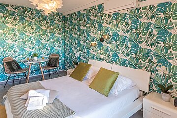 A bedroom with a bed and a table and chairs