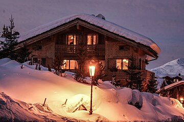 A snowy house with a lantern in front of it