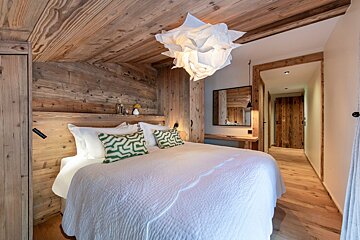 A bedroom with a white bed and green pillows