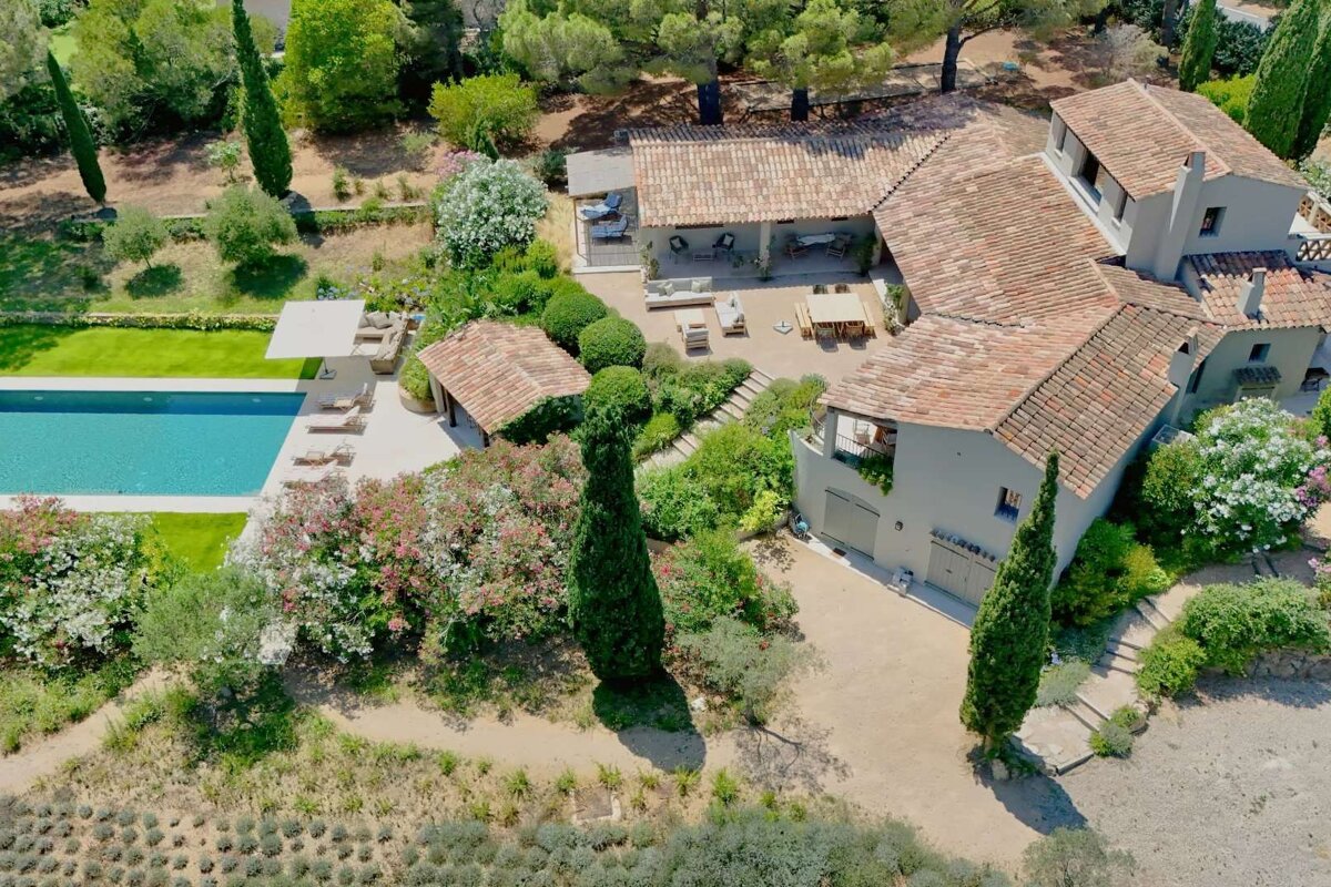 An aerial view of a large house with a large pool