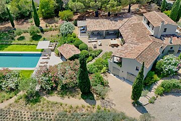 An aerial view of a large house with a large pool