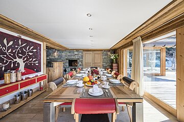 A dining room with a large table and chairs