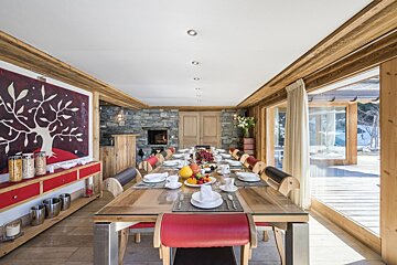 A dining room with a large table and chairs