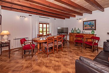 A living room with a table and chairs and a television