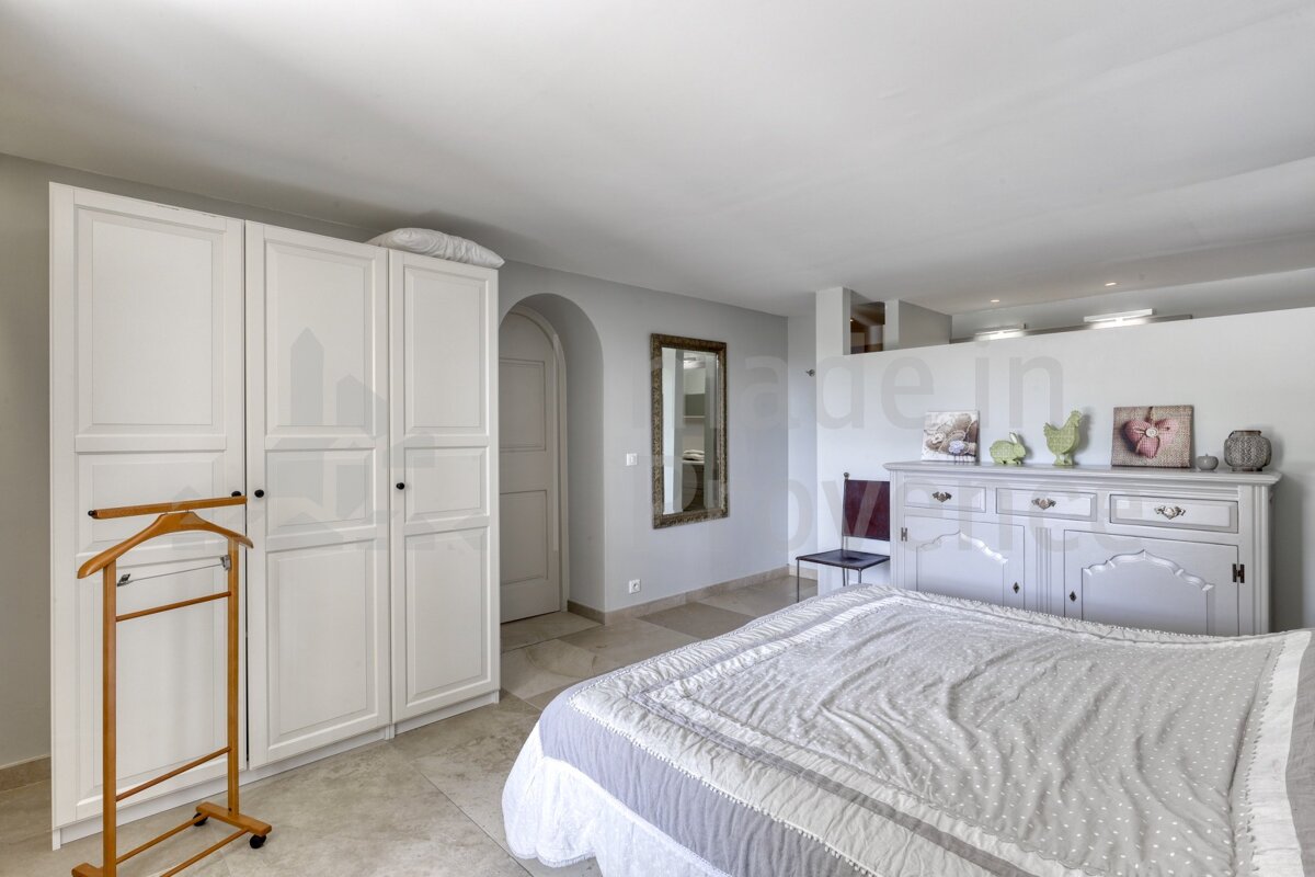 A bedroom with a bed and a dresser with a picture of a couple on it