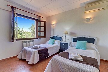 A bedroom with two twin beds and a window