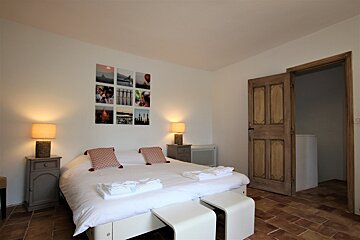 A bedroom with a large bed and pictures on the wall