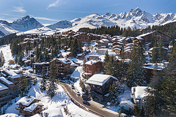 A snowy village with mountains in the background