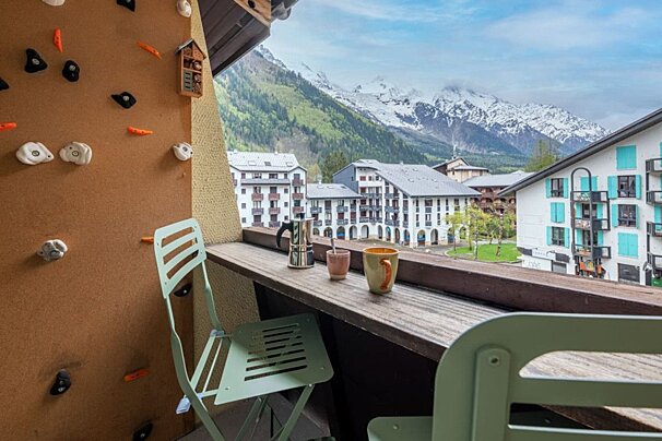 A balcony with a view of mountains and buildings