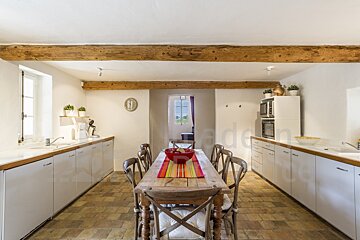 A kitchen with a long wooden table and chairs