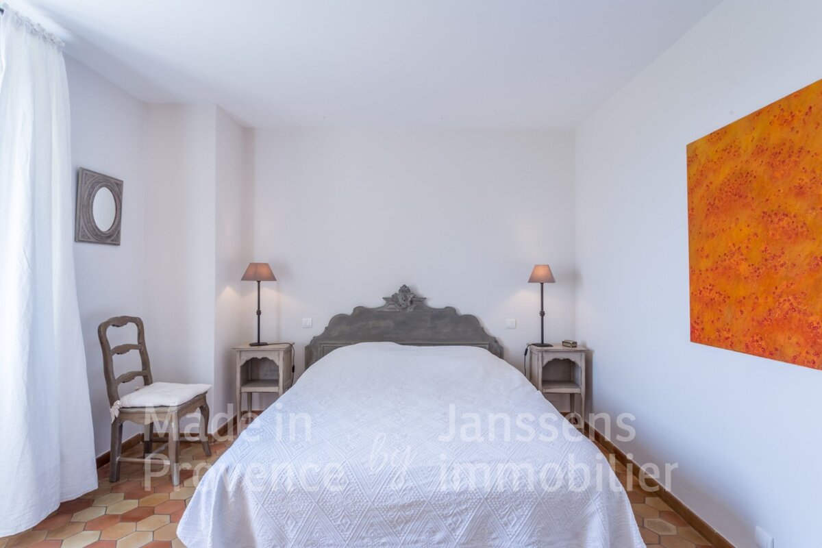 A bedroom with a bed made in provence by janssens immobilier