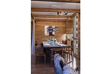 A dining room with a long table and chairs